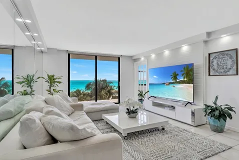 a living room with furniture potted plant and a large window