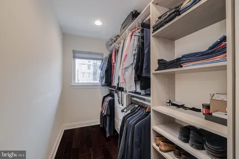 a view of walk in closet with clothes and shoes