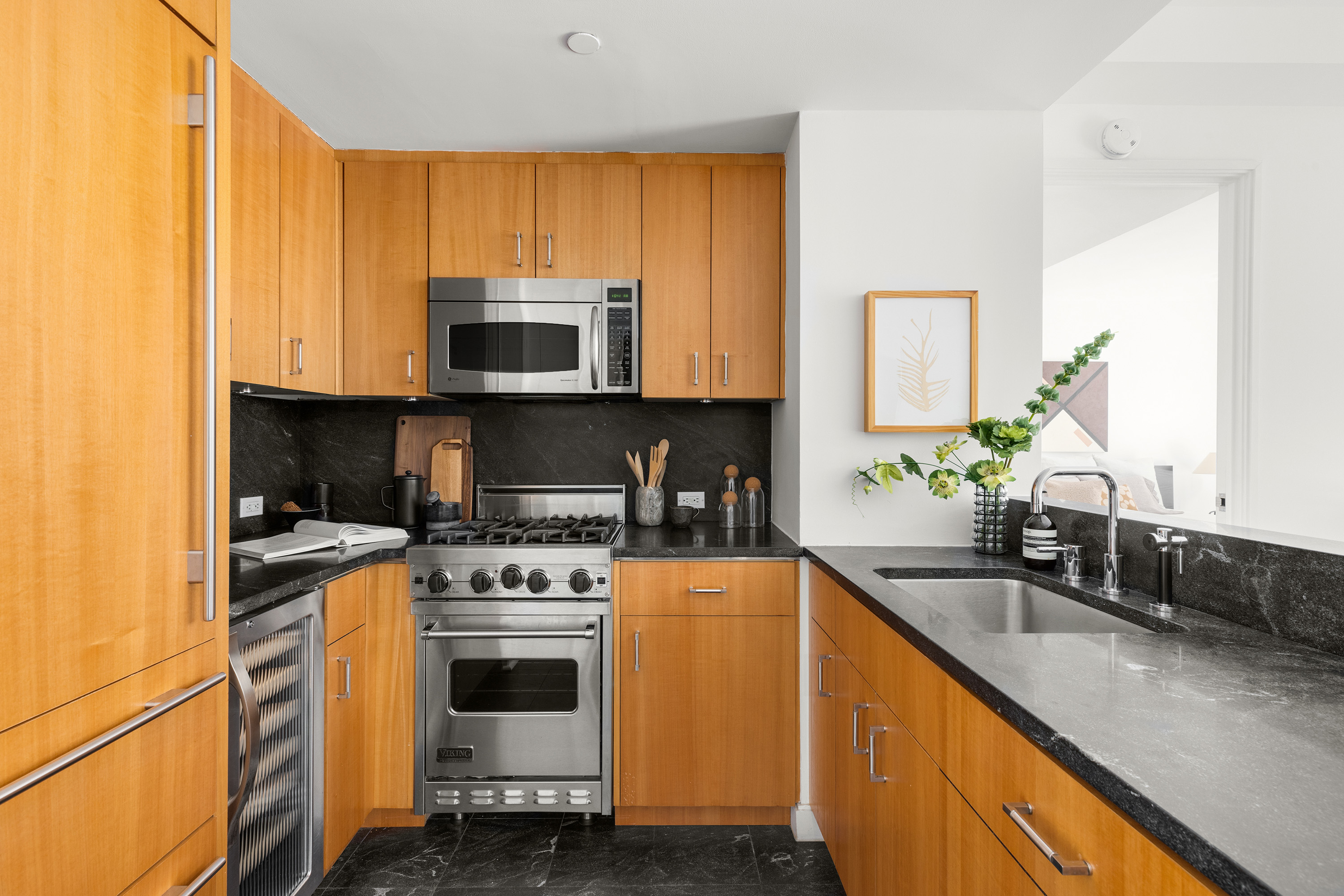 100 West 58th Street, Unit 8C Manhattan, NY 10019 - Photo 4 of 11 a kitchen with a stove a sink and a microwave