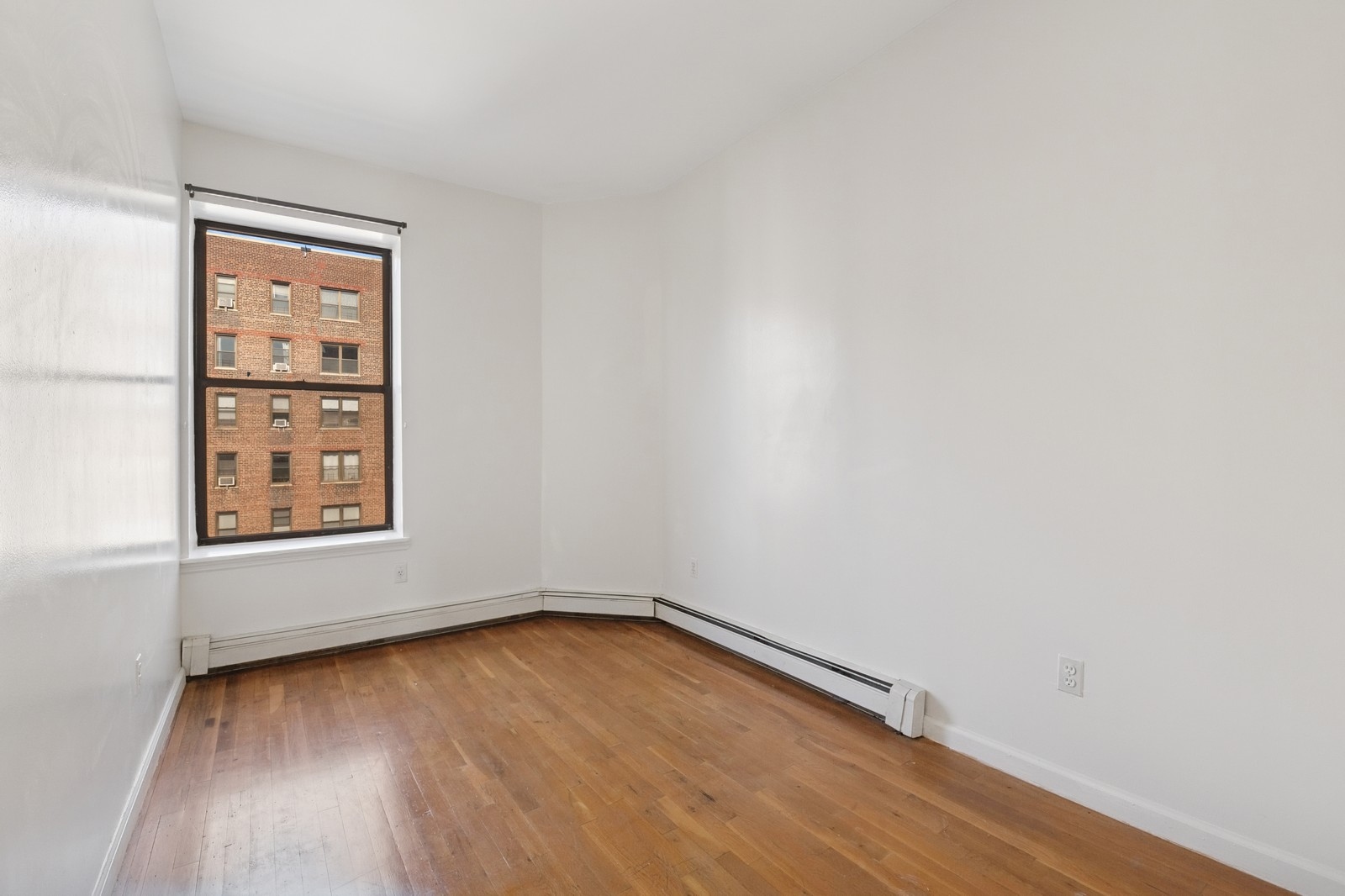 859 Riverside Drive, Unit 3 Manhattan, NY 10032 - Photo 6 of 7 wooden floor in an empty room with a window
