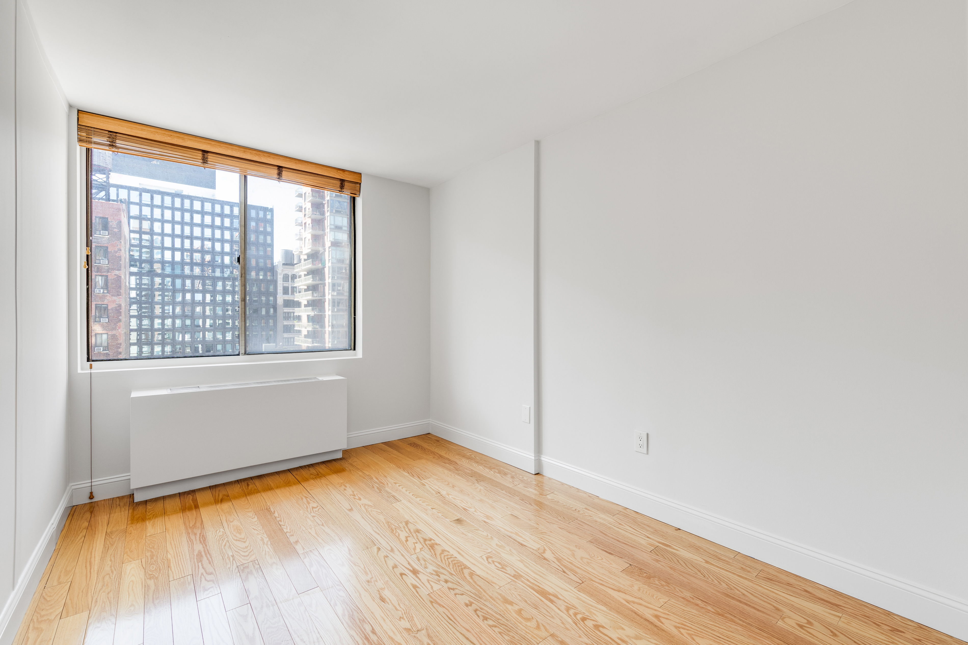 50 Lexington Avenue, Unit 12G Manhattan, NY 10010 - Photo 2 of 8 an empty room with wooden floor and windows