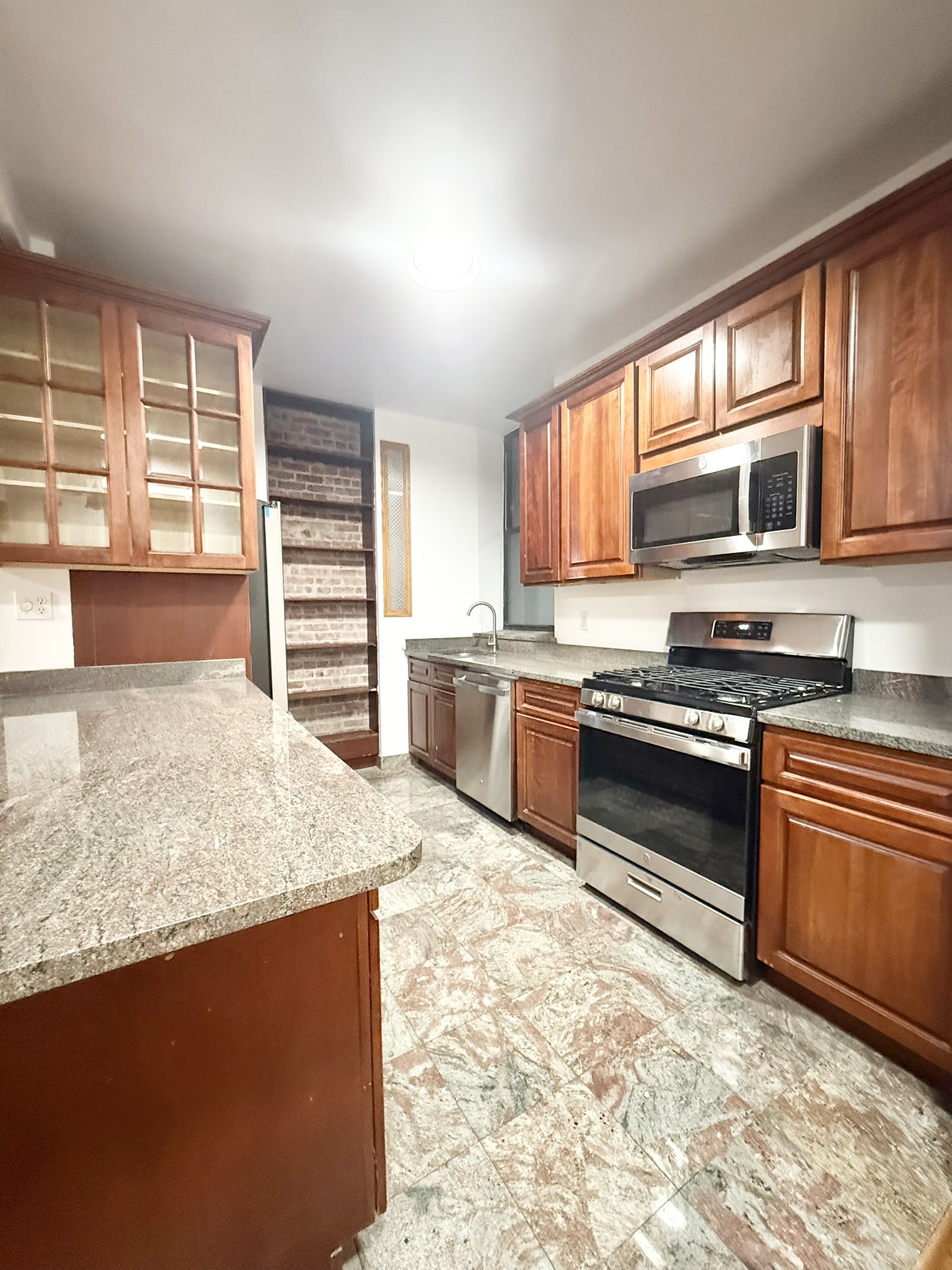 839 West End Avenue, Unit 3D Manhattan, NY 10025 - Photo 2 of 10 a kitchen with stainless steel appliances granite countertop a stove a sink and a microwave