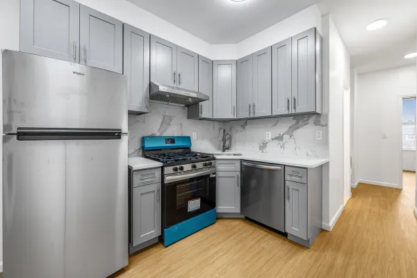 a kitchen with stainless steel appliances granite countertop a refrigerator a stove a sink and white cabinets