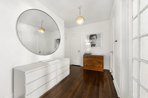 an entryway with wooden floor and mirror