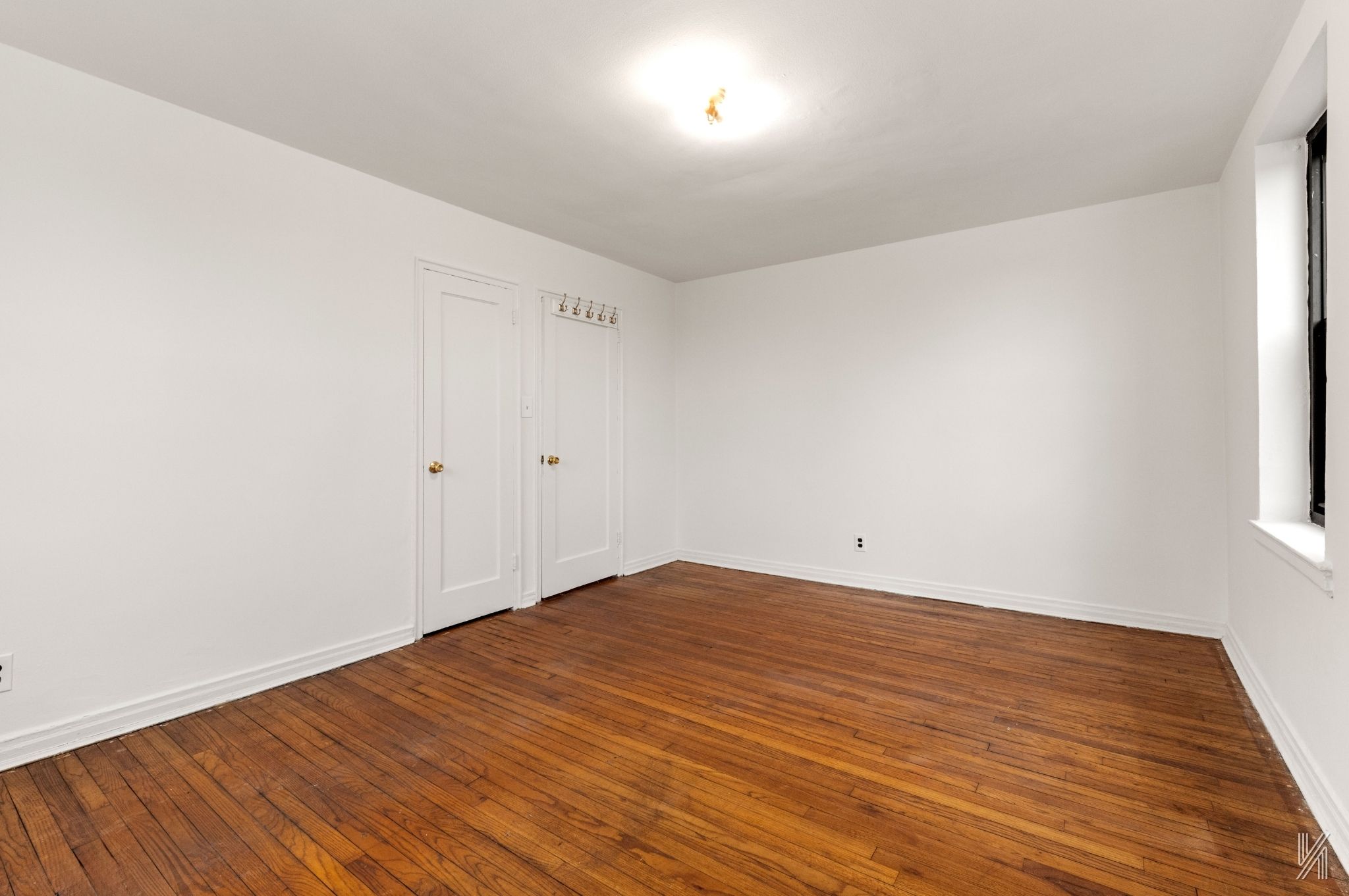 22-60 79th Street, Unit 3E Queens, NY 11370 - Photo 6 of 17 a view of empty room with wooden floor