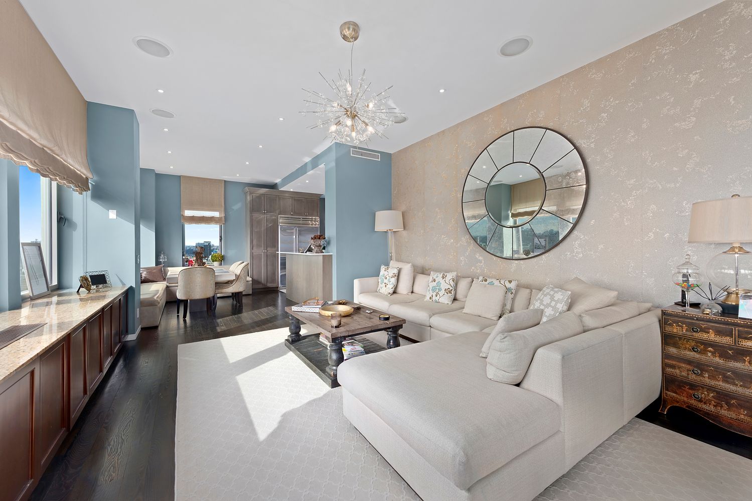 a living room with furniture a chandelier and a large mirror