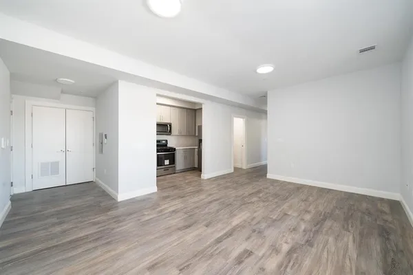 a view of empty room with wooden floor