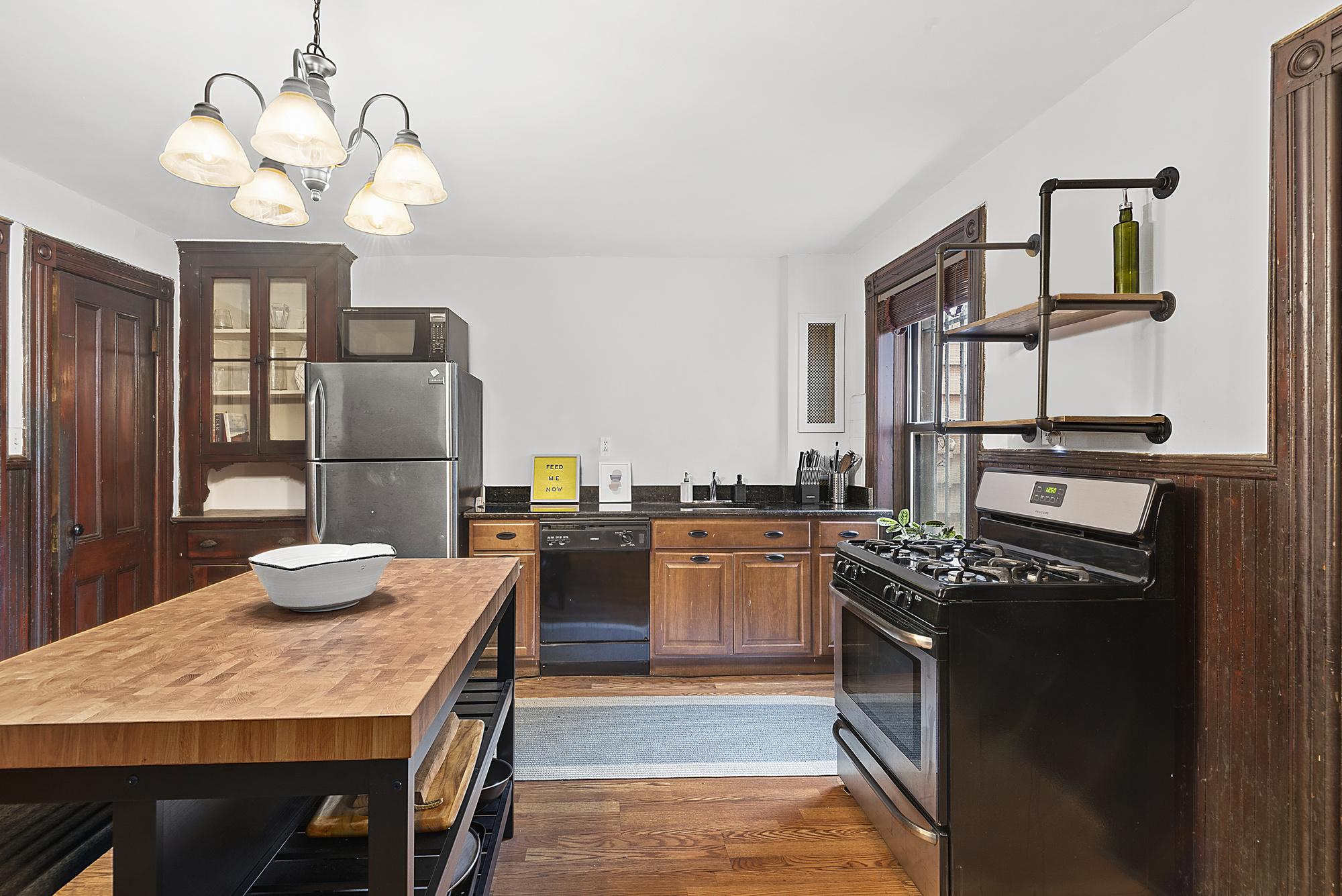 291 Sterling Place Brooklyn, NY 11238 - Photo 18 of 19 a kitchen with stainless steel appliances granite countertop a stove refrigerator a dining table and chairs with wooden floor