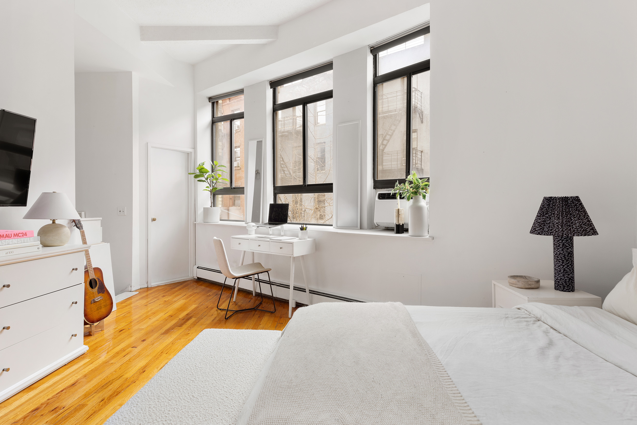 2 Cornelia Street, Unit 201 Manhattan, NY 10014 - Photo 4 of 11 a bedroom with a bed and large windows