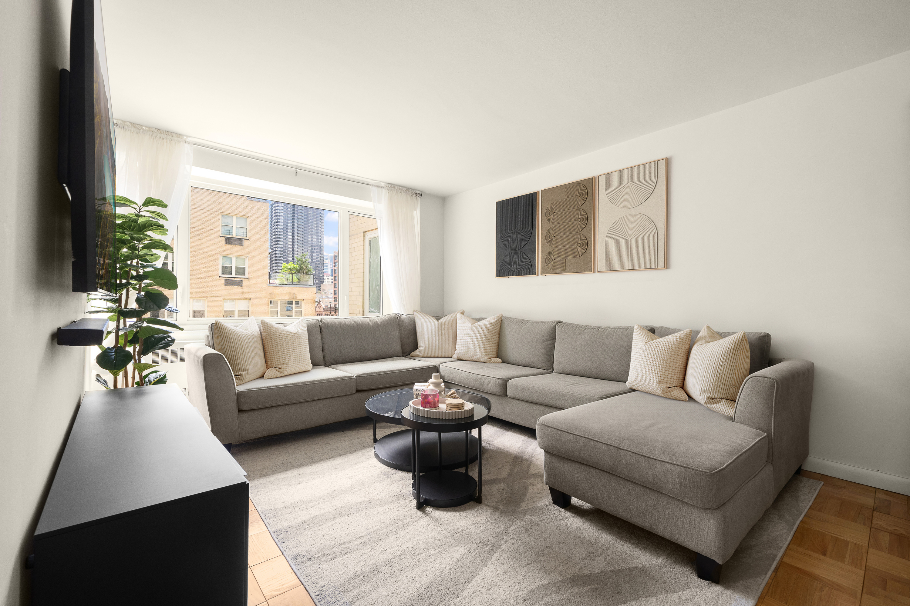 411 East 53rd Street, Unit 10E Manhattan, NY 10022 - Photo 1 of 8 a living room with furniture and a large window