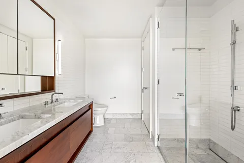 a bathroom with a granite countertop sink mirror and shower