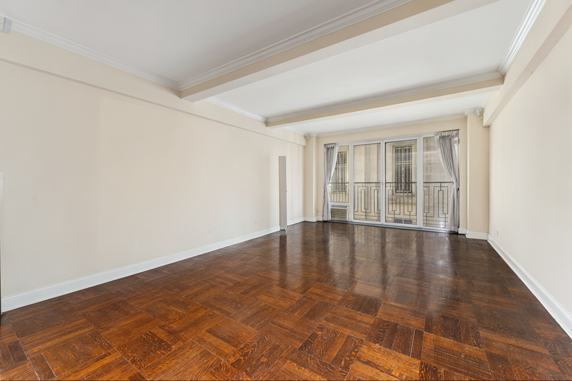 230 Central Park South, Unit 8F Manhattan, NY 10019 - Photo 2 of 7 an empty room with wooden floor and windows