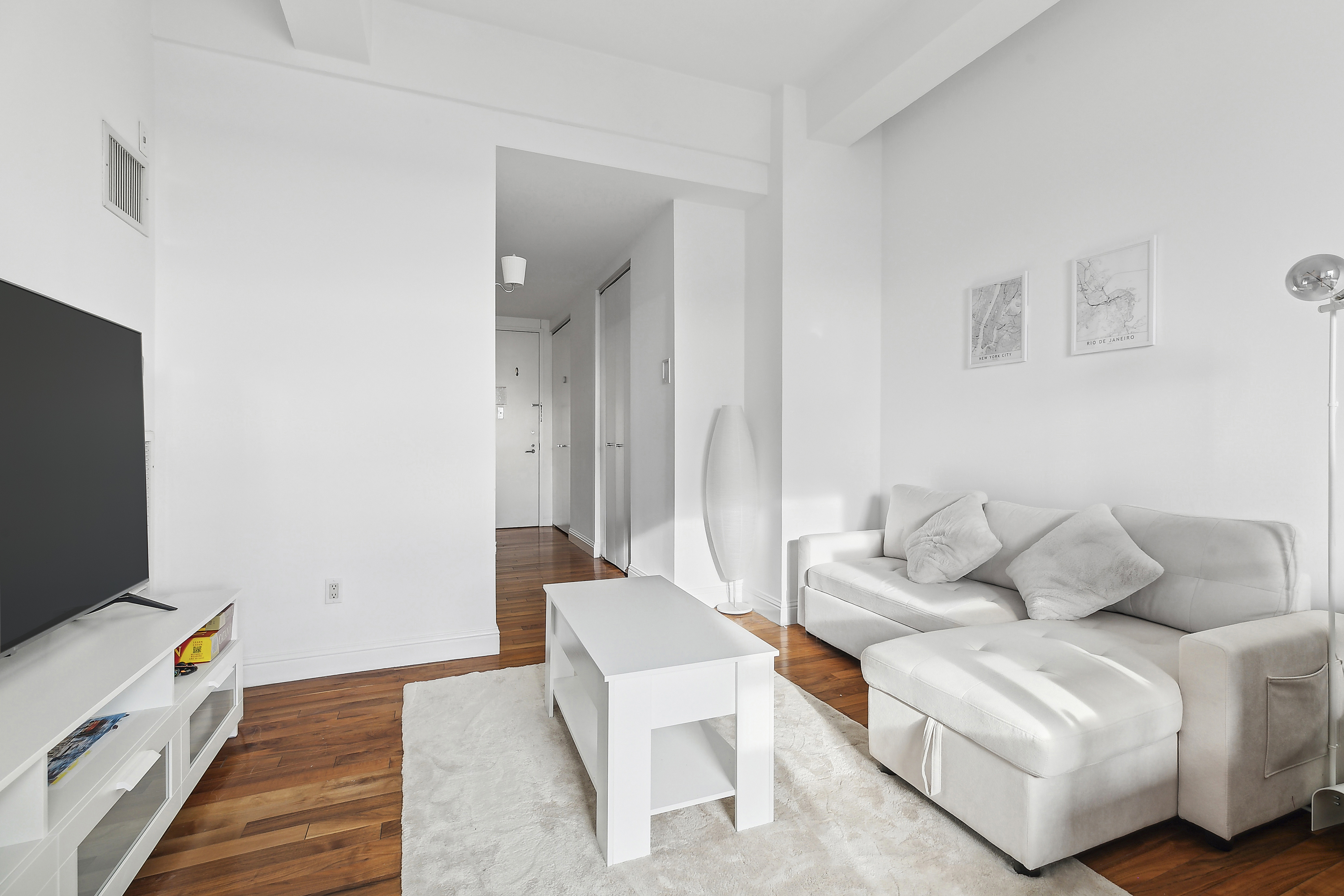 88 Greenwich Street, Unit 3003 Manhattan, NY 10006 - Photo 2 of 19 a living room with furniture and a flat screen tv