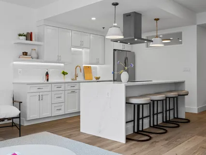 a kitchen with a white cabinets and chandelier