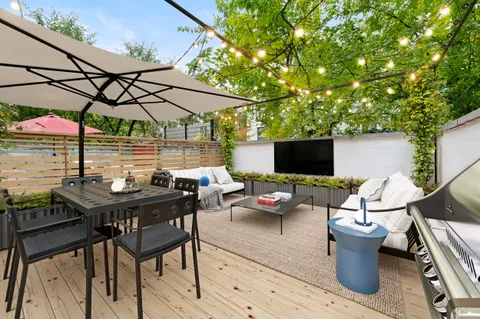 a view of a patio with table and chairs under an umbrella
