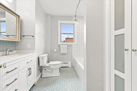 a bathroom with a toilet sink and mirror