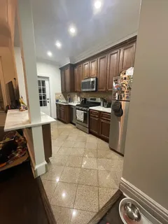 a kitchen with kitchen island granite countertop a stove refrigerator and microwave