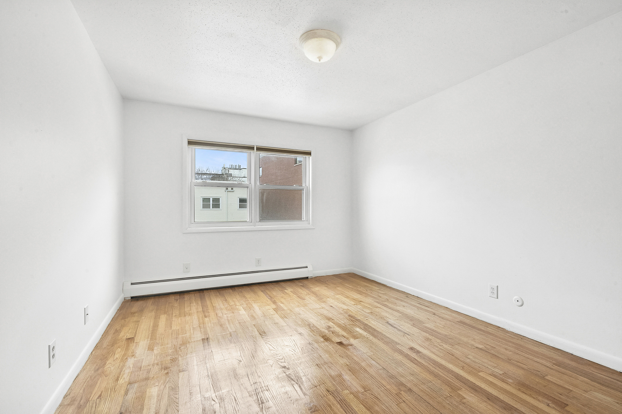 97 Baltic Street, Unit 3 Brooklyn, NY 11201 - Photo 4 of 9 an empty room with wooden floor and windows