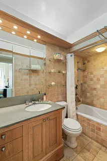 a bathroom with a granite countertop sink toilet a large mirror a shower and a bathtub