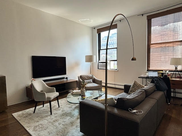 250 Mercer Street, Unit D603 Manhattan, NY 10012 - Photo 15 of 20 a living room with furniture and a flat screen tv