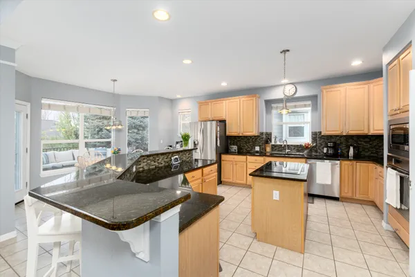 a kitchen with stainless steel appliances granite countertop a stove a sink and a refrigerator
