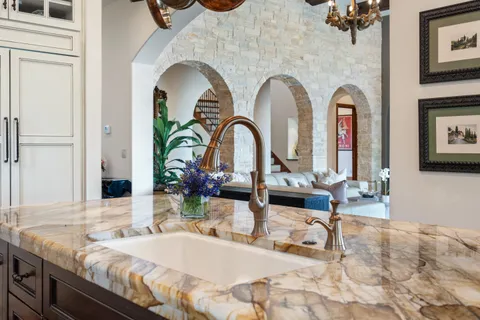 a kitchen with a granite countertop sink and a refrigerator