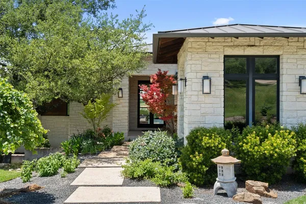 a front view of a house with a garden