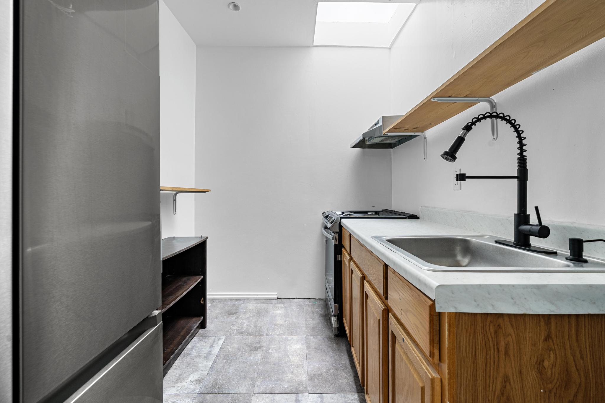 43 Linden Street, Unit 3 Brooklyn, NY 11221 - Photo 4 of 8 a kitchen with a sink and a refrigerator