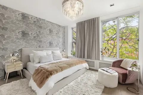 a bedroom with a bed and a chandelier