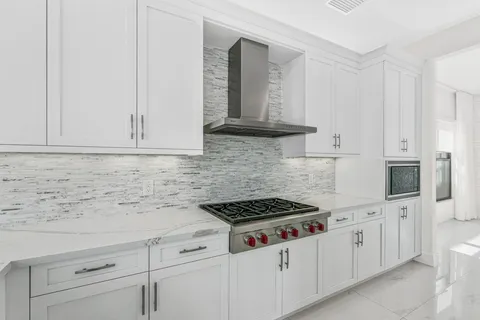 a kitchen with white cabinets and white appliances