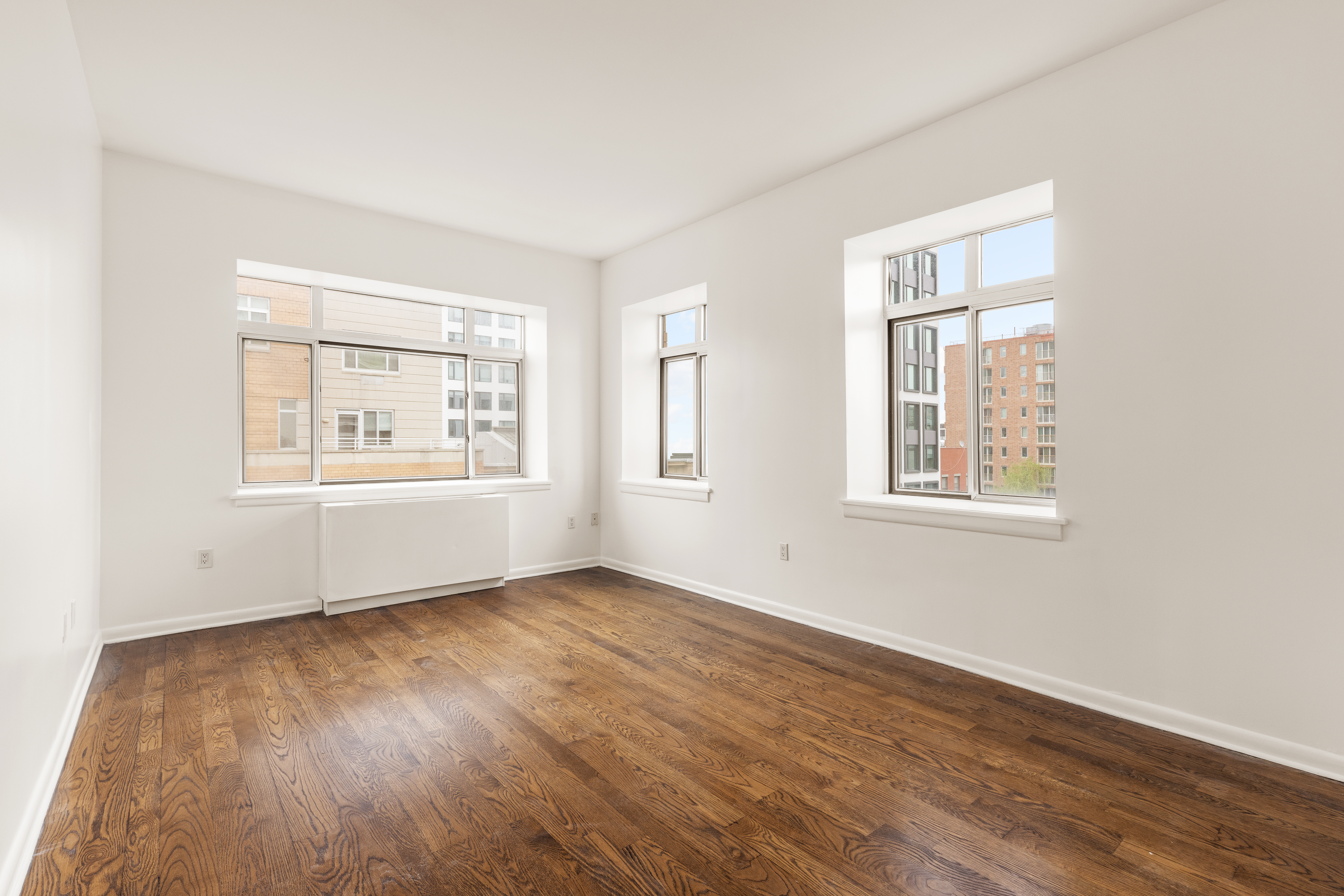 2279 3rd Avenue, Unit 6B Manhattan, NY 10035 - Photo 4 of 10 a view of an empty room with wooden floor and a window