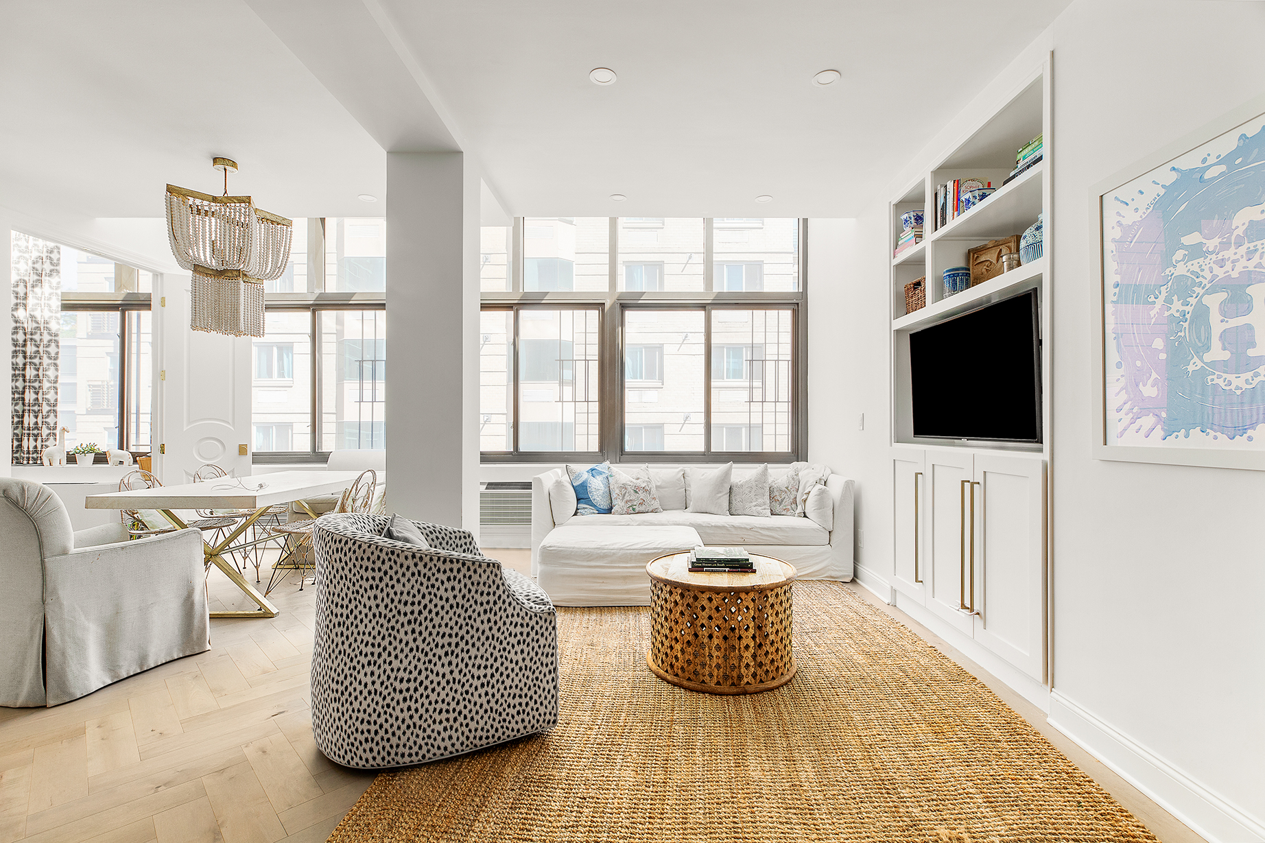 a living room with furniture a flat screen tv and a large window