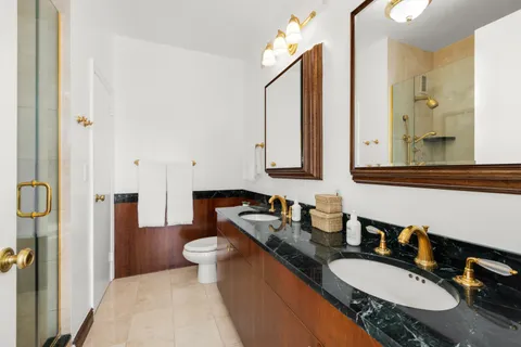 a bathroom with a granite countertop double vanity sink and a mirror