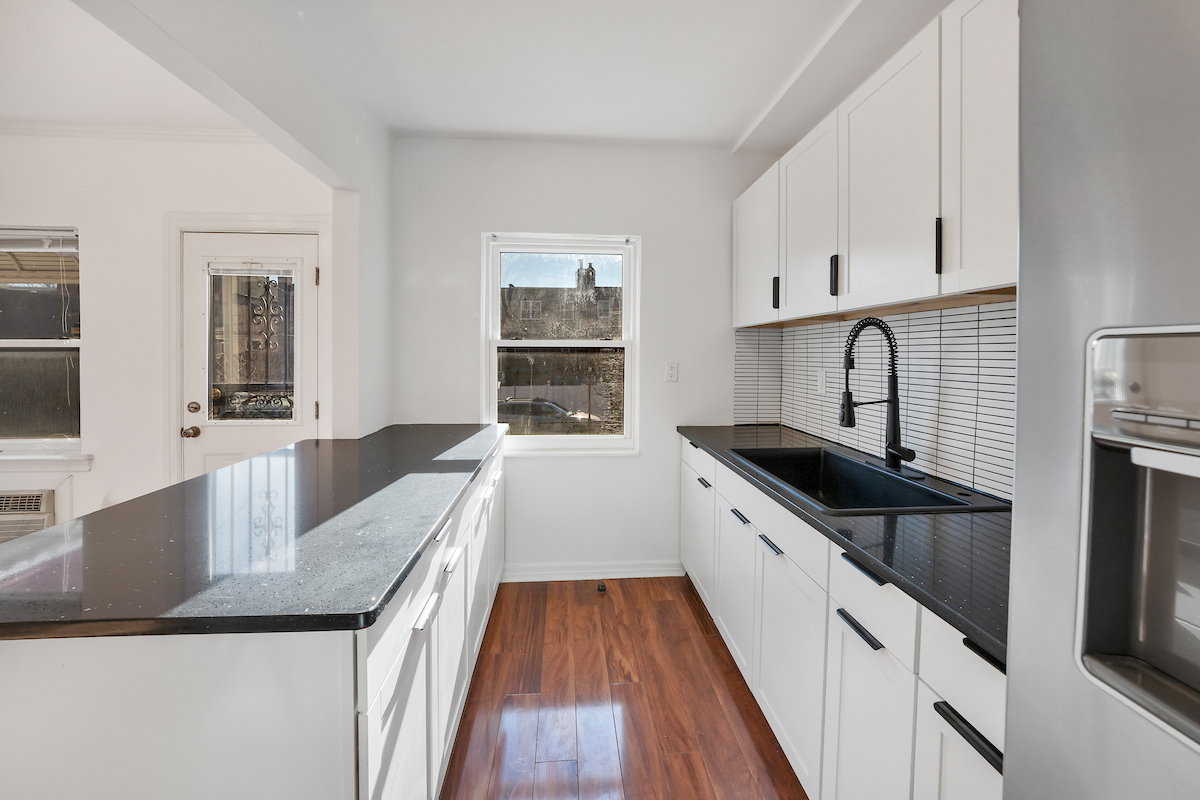 82-56 Eliot Avenue Queens, NY 11379 - Photo 3 of 7 a kitchen with granite countertop a sink dishwasher stove and oven with wooden floor
