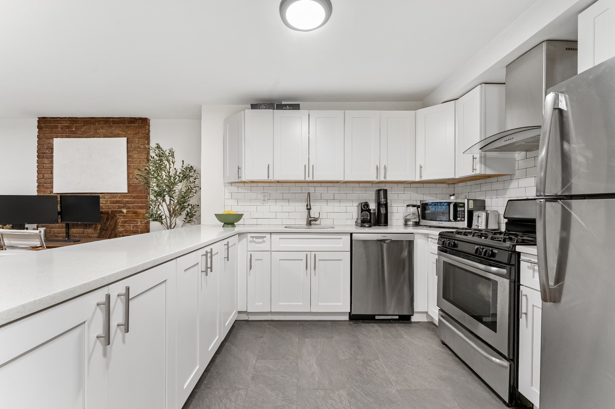 355 West 20th Street, Unit 1 Manhattan, NY 10011 - Photo 4 of 9 a kitchen with white cabinets and white appliances