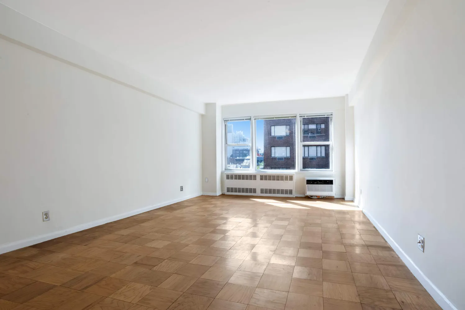 an empty room with floor to ceiling window and floor