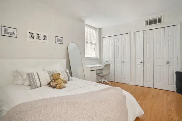 a bedroom with a bed a mirror and a window