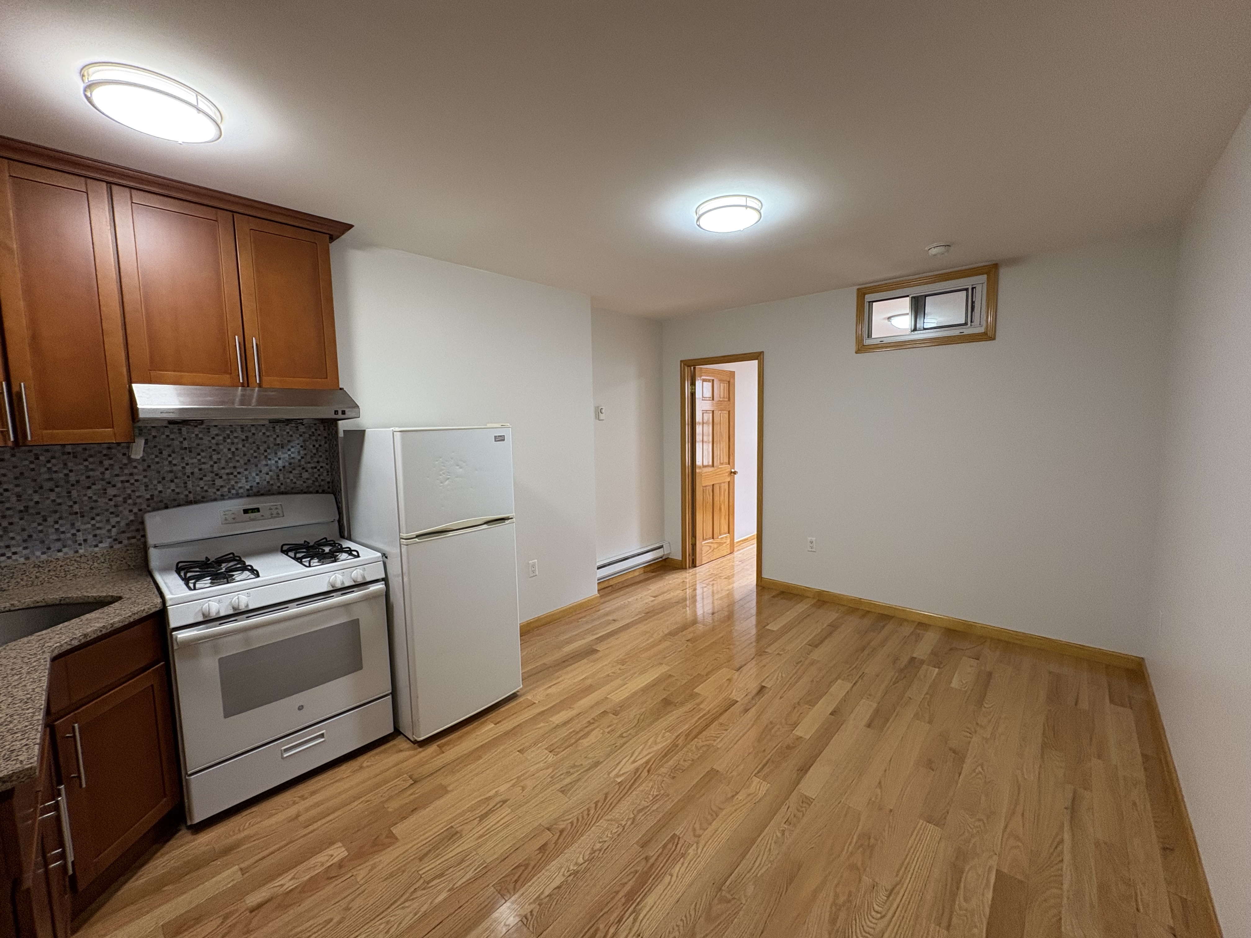 38 Ludlow Street, Unit 15 Manhattan, NY 10002 - Photo 12 of 16 a kitchen with a stove a sink and a refrigerator