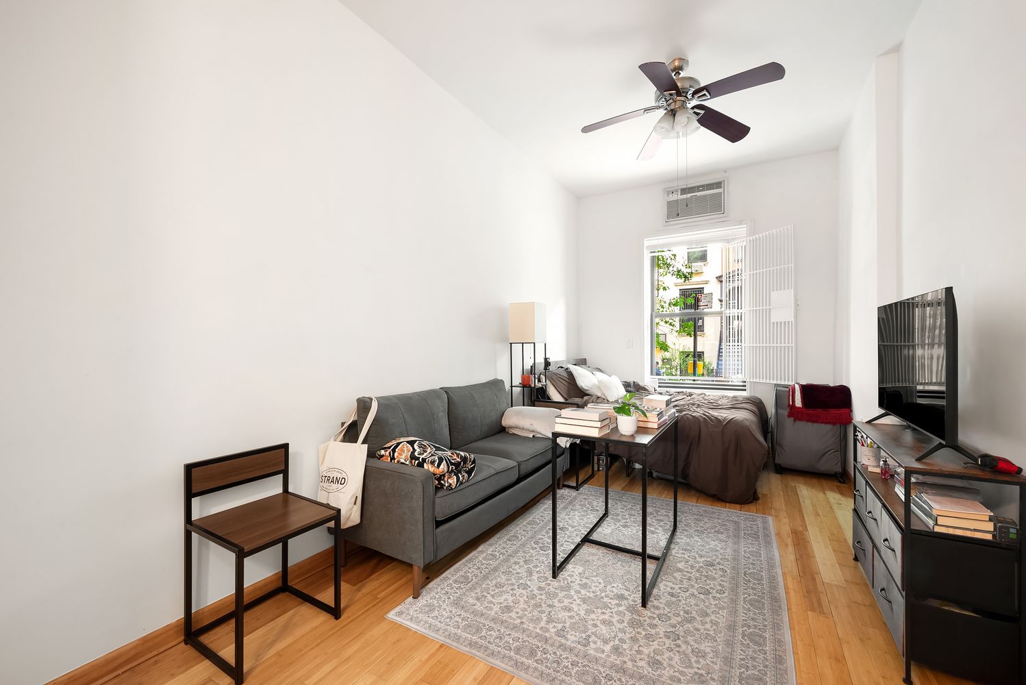 430 East 85th Street, Unit 1B Manhattan, NY 10028 - Photo 2 of 8 a living room with furniture a ceiling fan and a window