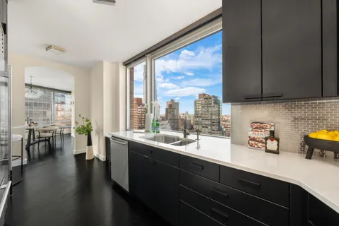 a kitchen with a sink and wooden floor