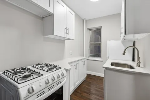 a kitchen with white cabinets and appliances