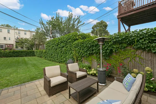 a view of a patio with couches table and chairs and garden
