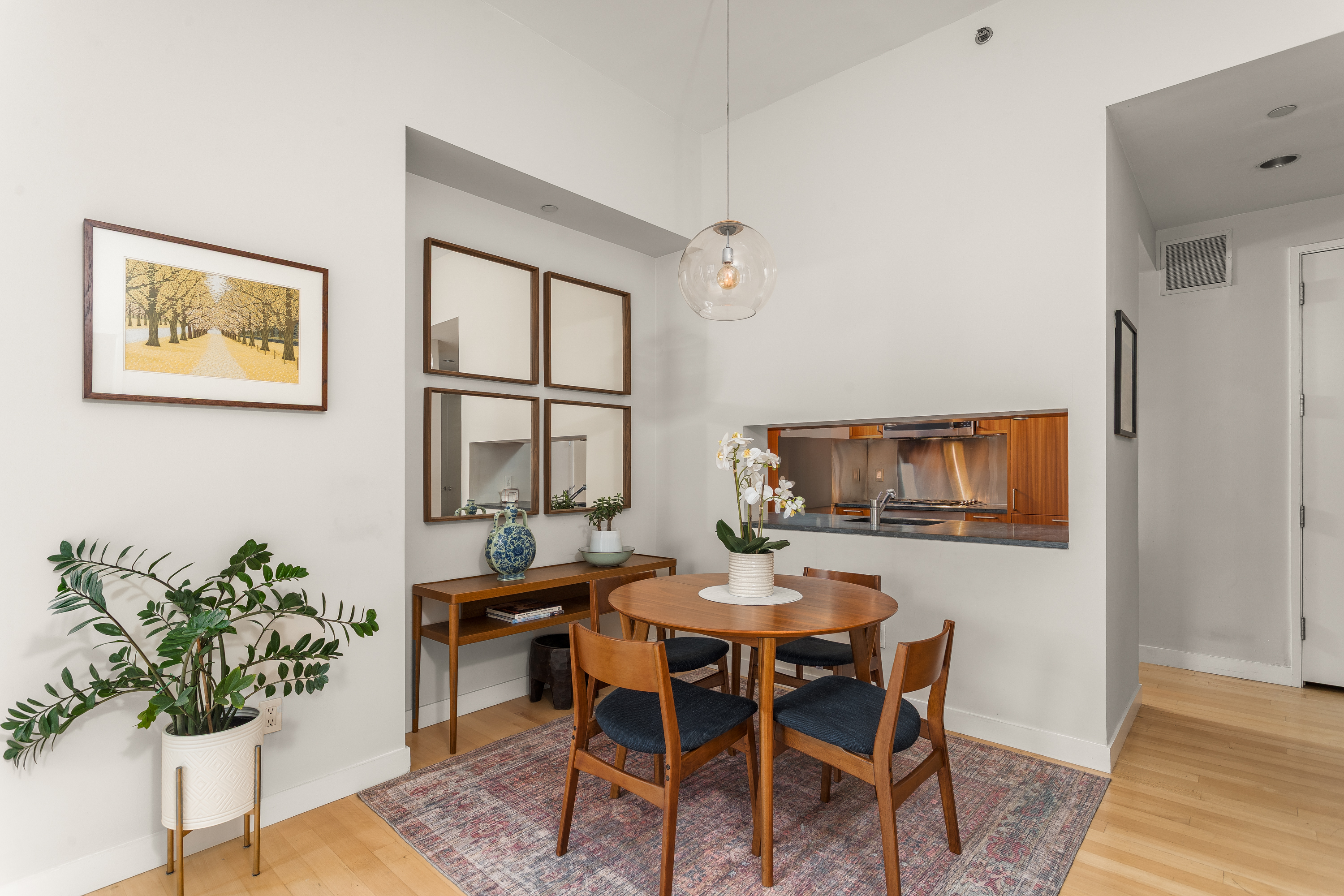 450 East 83rd Street, Unit 5K Manhattan, NY 10028 - Photo 6 of 16 a dining room with furniture potted plants and wooden floor