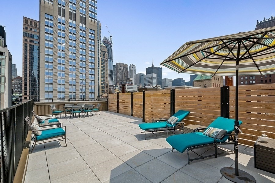 372 5th Avenue, Unit 5N Manhattan, NY 10018 - Photo 7 of 13 a view of a chairs and table in the patio with a yard