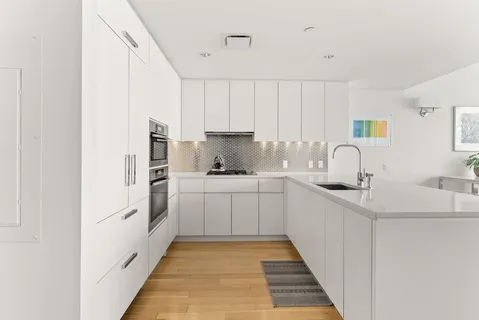 a kitchen with white cabinets and white appliances