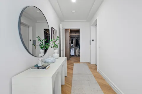 a view of a hallway with wooden floor and entryway