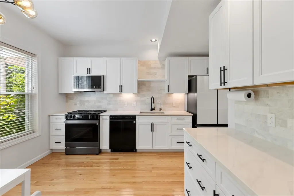 a kitchen with granite countertop a sink stove and refrigerator