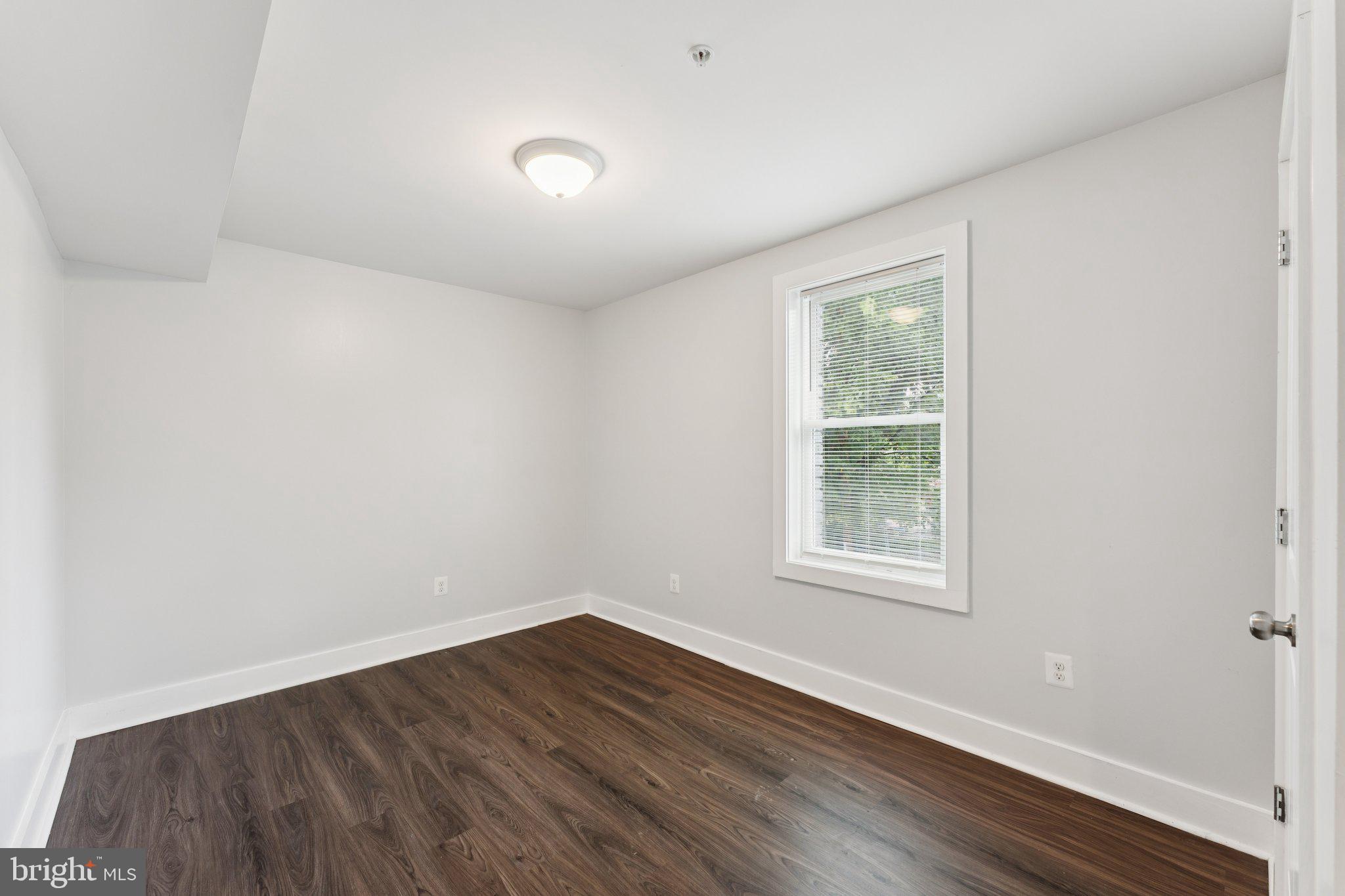 2822 28th Street Southeast Washington, DC 20020 - Photo 3 of 57 an empty room with wooden floor and windows