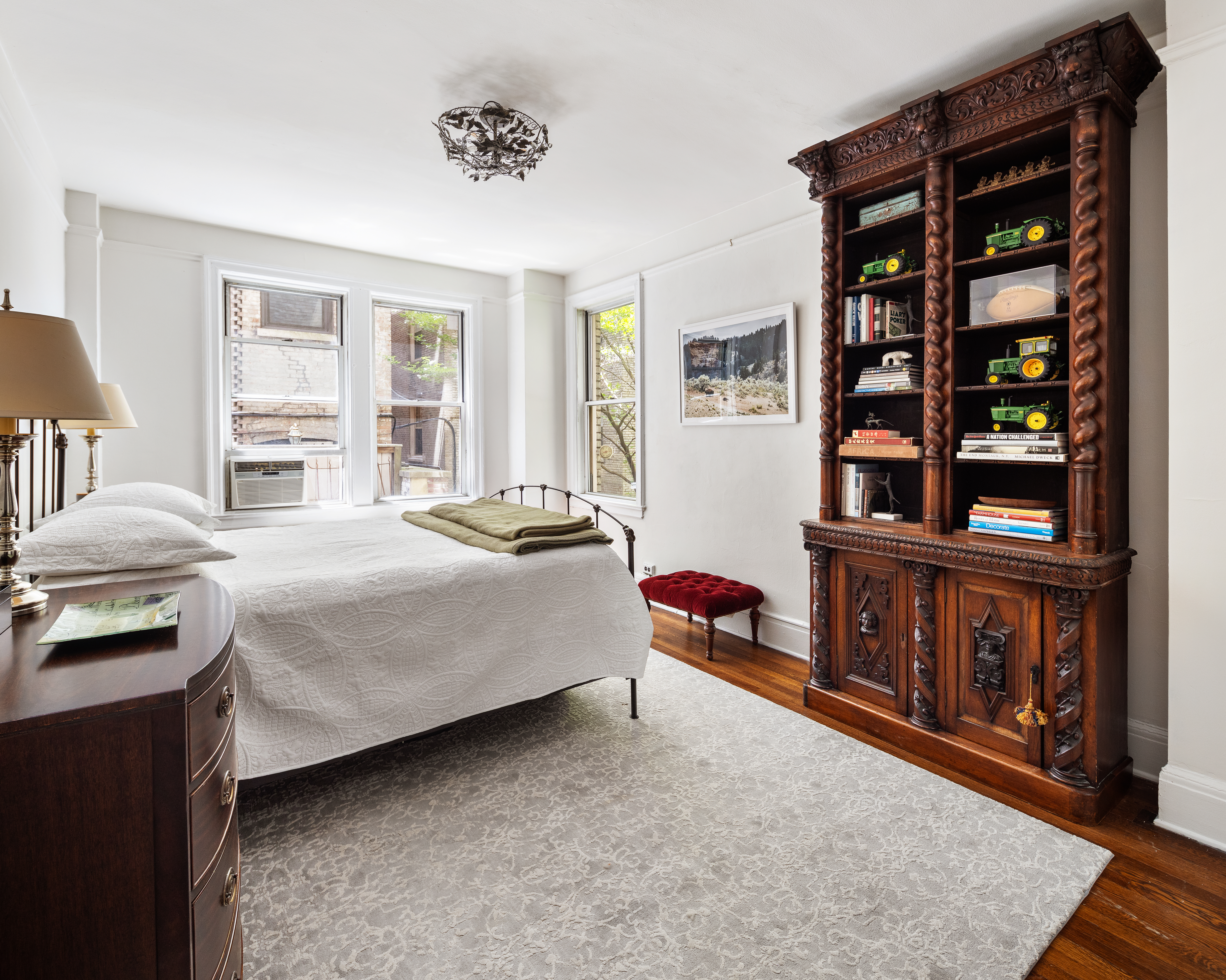 173-175 Riverside Drive, Unit 2L Manhattan, NY 10024 - Photo 7 of 18 a bedroom with a bed a dresser and book shelf
