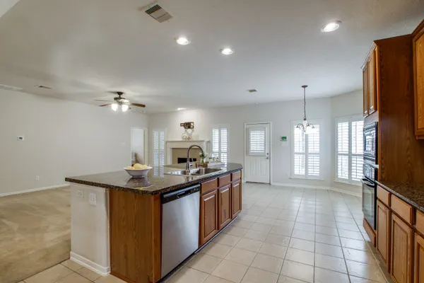 a kitchen with stainless steel appliances granite countertop a sink a stove counter space and cabinets